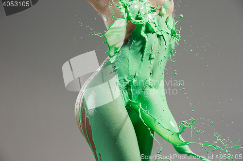 Image of The beautiful woman with green liquid paint over her body