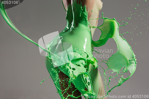 Image of The beautiful woman with green liquid paint over her body