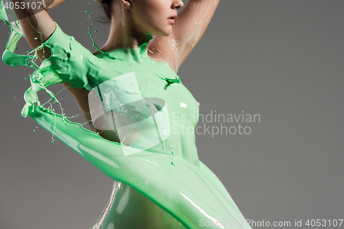 Image of The beautiful woman with green liquid paint over her body