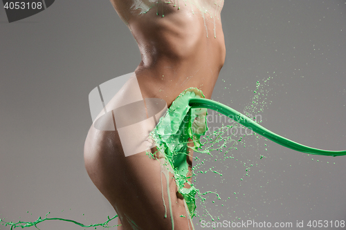 Image of The beautiful woman with green liquid paint over her body