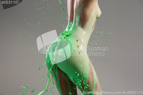 Image of The beautiful woman with green liquid paint over her body