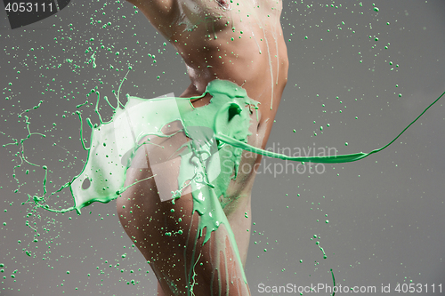 Image of The beautiful woman with green liquid paint over her body