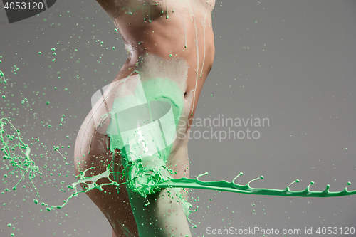 Image of The beautiful woman with green liquid paint over her body