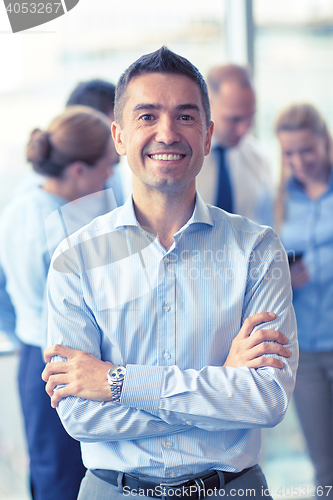 Image of group of smiling businesspeople meeting in office