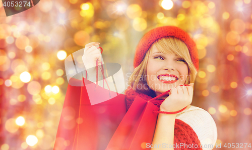 Image of happy woman in winter clothes with shopping bags