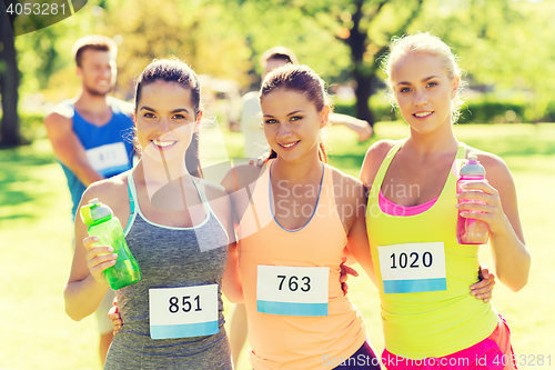 Image of women with racing badge numbers and water bottles