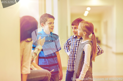 Image of group of smiling school kids talking in corridor