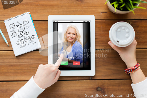 Image of close up of woman with tablet pc on wooden table