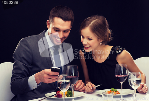 Image of smiling couple eating main course at restaurant