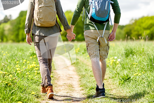 Image of close up of couple with backpacks walking on road