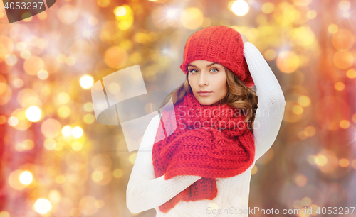 Image of happy woman in hat, scarf and pullover over lights