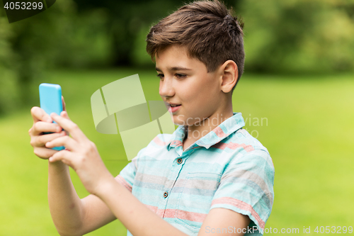 Image of boy with smartphone playing game in summer park