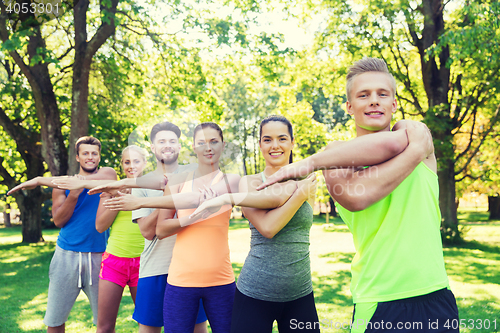 Image of group of friends or sportsmen exercising outdoors