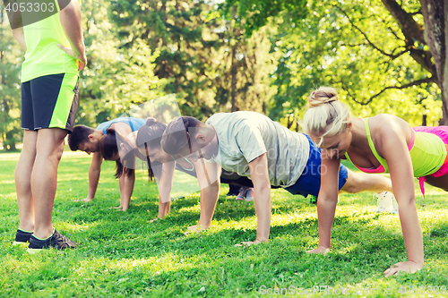 Image of group of friends or sportsmen exercising outdoors