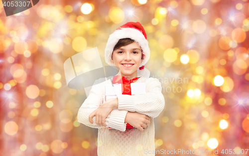 Image of smiling happy boy in santa hat with gift box