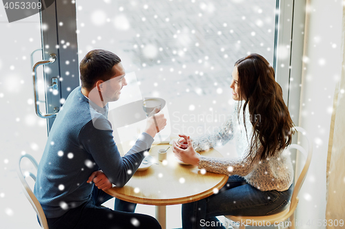 Image of happy couple drinking tea and coffee at cafe