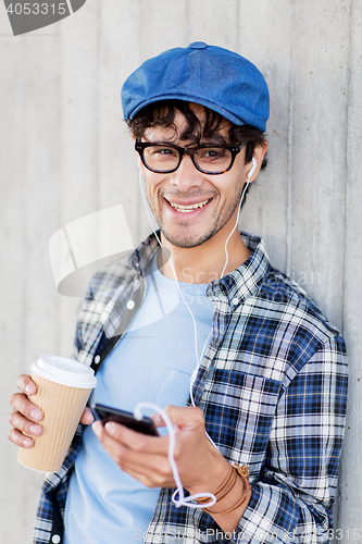 Image of man with earphones and smartphone drinking coffee