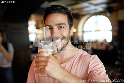 Image of close up of happy man drinking beer at bar or pub