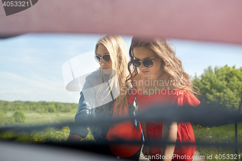 Image of women with open hood of broken car at countryside