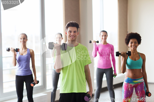 Image of group of smiling people working out with dumbbells