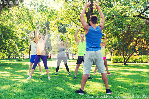 Image of group of friends or sportsmen exercising outdoors