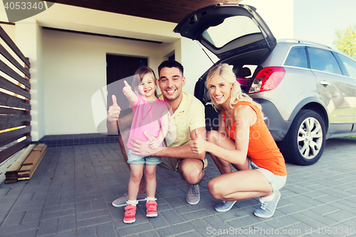 Image of happy family with car showing thumbs up at parking