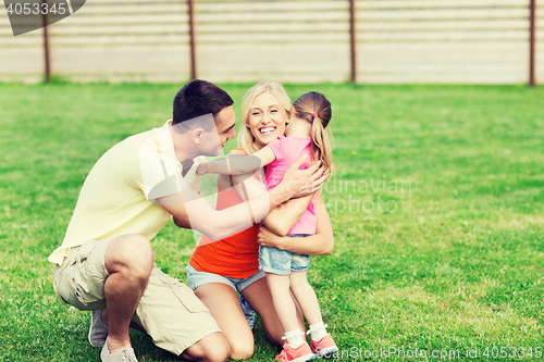 Image of happy family hugging outdoors