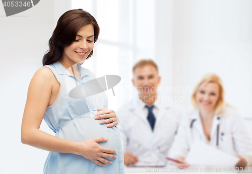 Image of happy pregnant woman touching her big belly