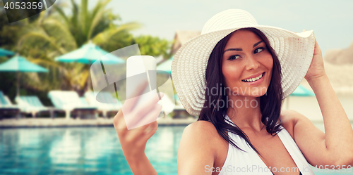 Image of young woman taking selfie with smartphone