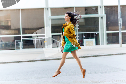 Image of happy young woman or teenage girl on city street