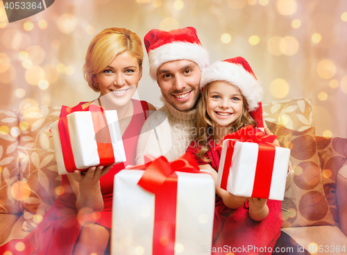 Image of smiling family giving many gift boxes