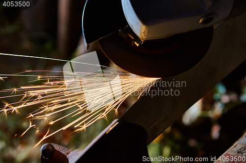 Image of Worker cutting metal with grinder. Sparks while grinding iron