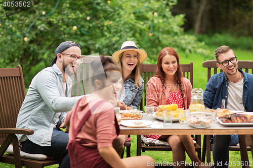 Image of happy friends having dinner at summer garden party