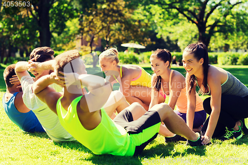 Image of group of friends or sportsmen exercising outdoors