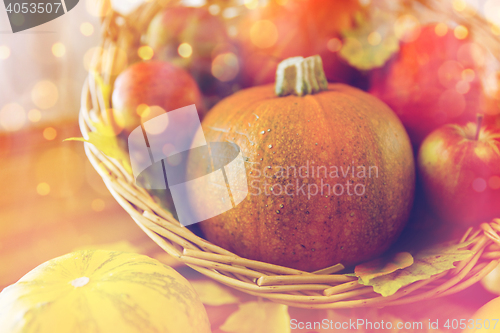 Image of close up of pumpkins in basket on wooden table