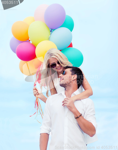 Image of couple with colorful balloons at seaside