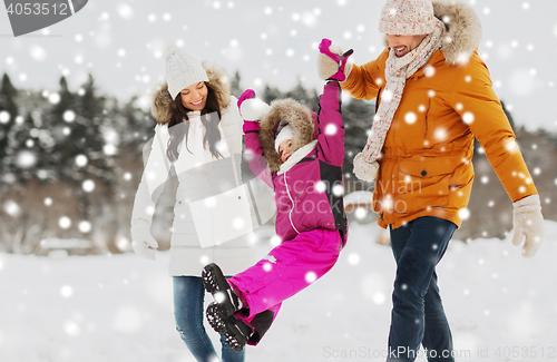 Image of happy family in winter clothes walking outdoors