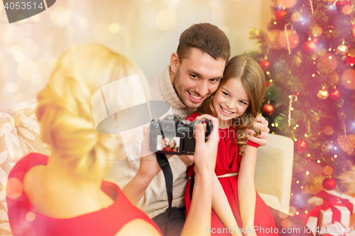 Image of mother taking picture of father and daughter