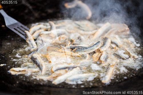 Image of close up of fried fish in pan at street market