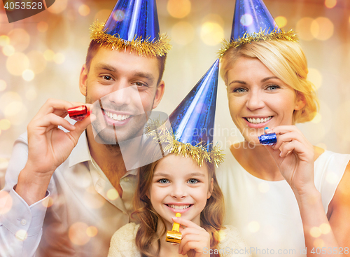 Image of smiling family in blue hats blowing favor horns