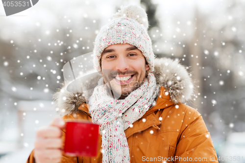 Image of happy man with tea cup outdoors in winter