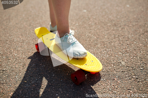 Image of close up of female feet riding short skateboard