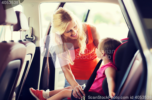 Image of happy mother fastening child with car seat belt