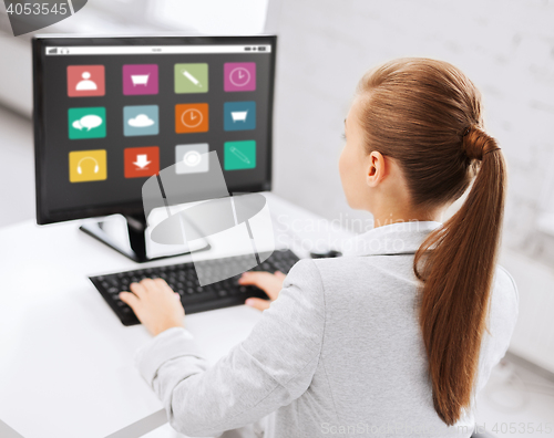 Image of businesswoman with menu icons on office computer