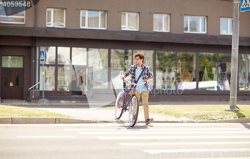 Image of young man with fixed gear bicycle on crosswalk