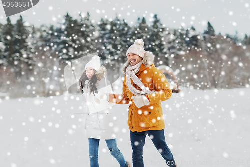 Image of happy couple running over winter background