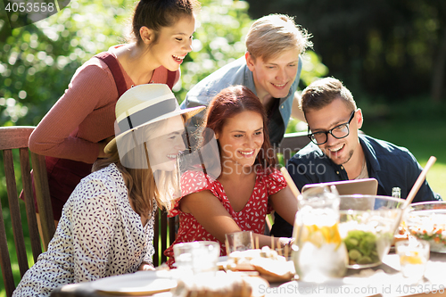 Image of friends with tablet pc at dinner in summer garden