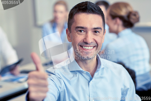 Image of group of smiling businesspeople meeting in office