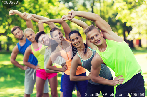 Image of group of friends or sportsmen exercising outdoors