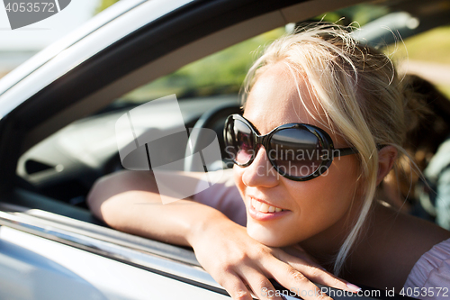 Image of happy teenage girl or young woman in car
